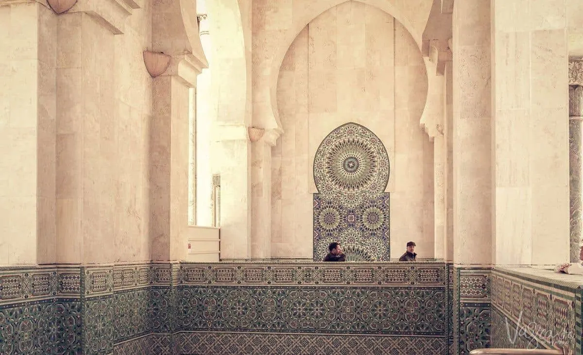 Two men standing in the ornate Hassan II Mosque in Casablanca Morocco. 