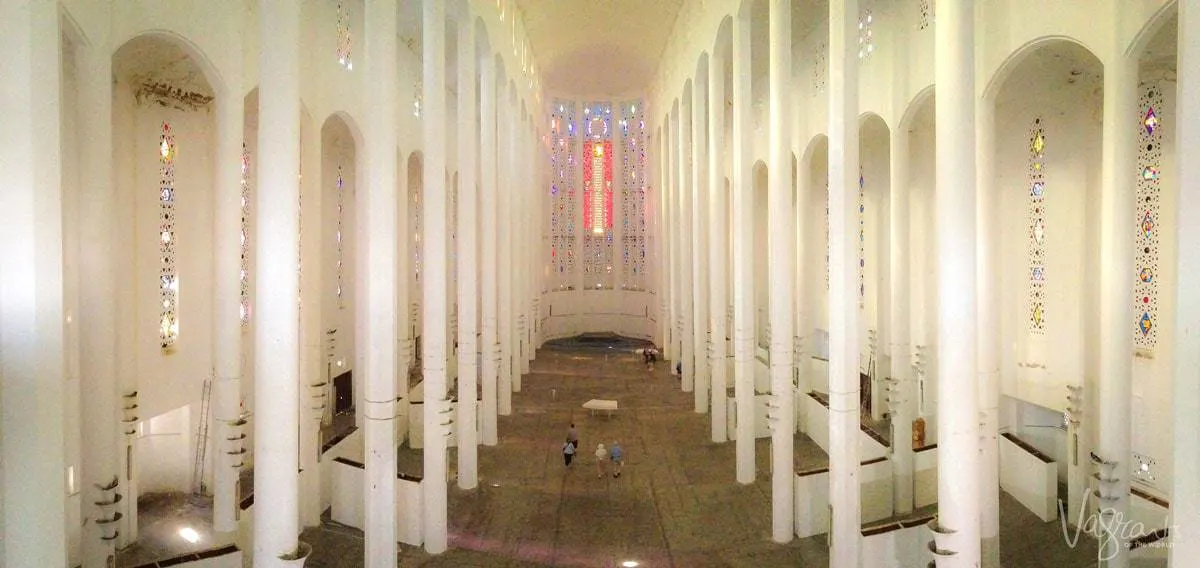 The inside of the Sacre Couer Cathedral in Casablanca, looking down the main aisle with stained glass windows in the front.
