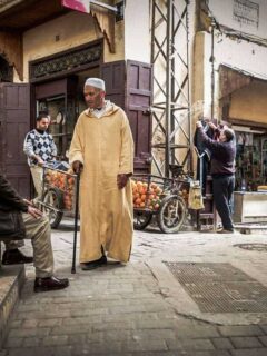 Man in traditional dress walking through Fez Medina