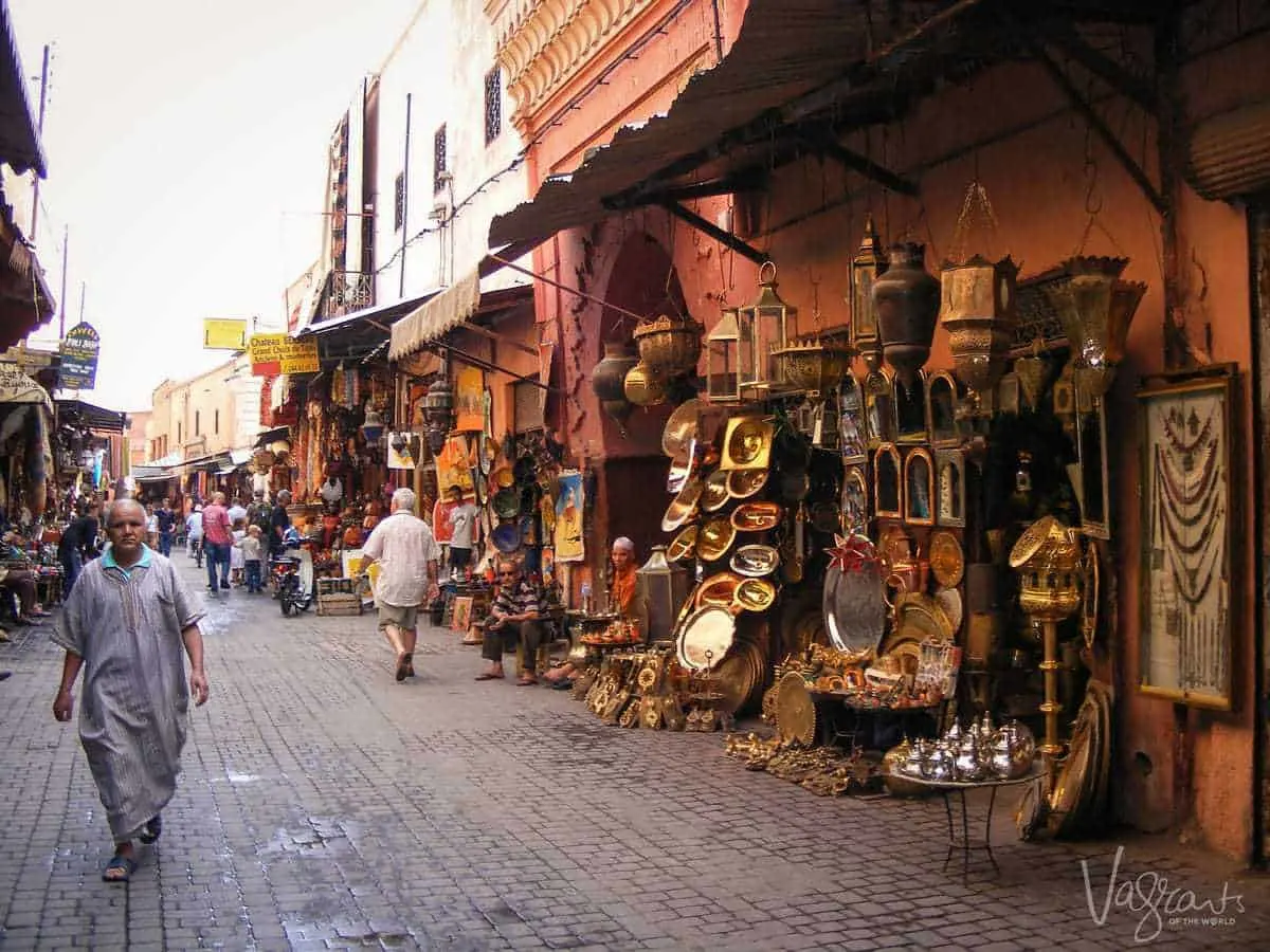 men walking past pot sellers in Marrakech Souk Morocco. Best free things to see and do in Marrakech Morocco