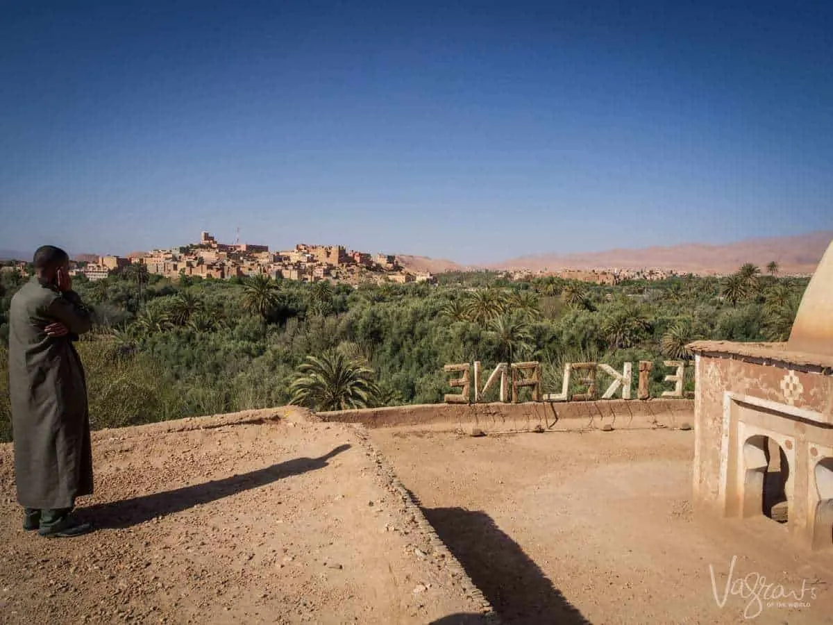 Moroccan Road trip guide - Marrakech to Fez -Man on rooftop looking out over Ouarzazate Morocco