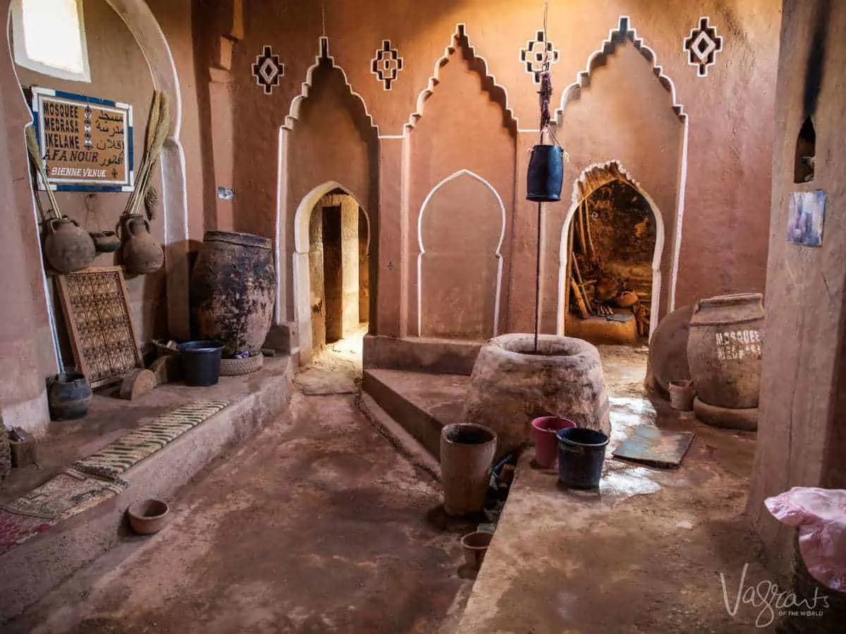 Unique things to see on a moroccan road trip from Marrakech to Fez -Ancient Mosque Ouarzazate Morocco. mosque with large urns and ornate wall, lit by olive oil lanterns. 