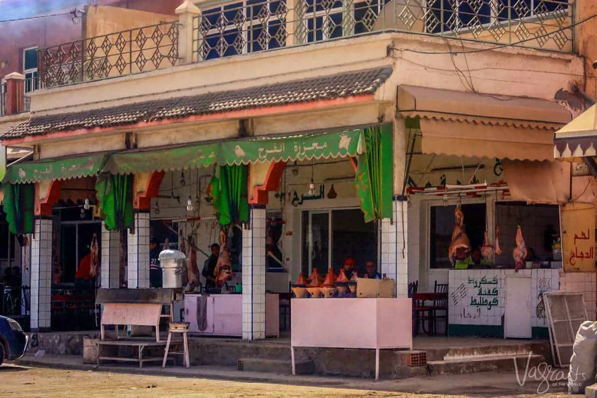 Restaurants in Zaida in the Midelt province Morocco with goat carcass hanging in the shop front and tagines ready to be cooked. The sights you see on a moroccan road trip.