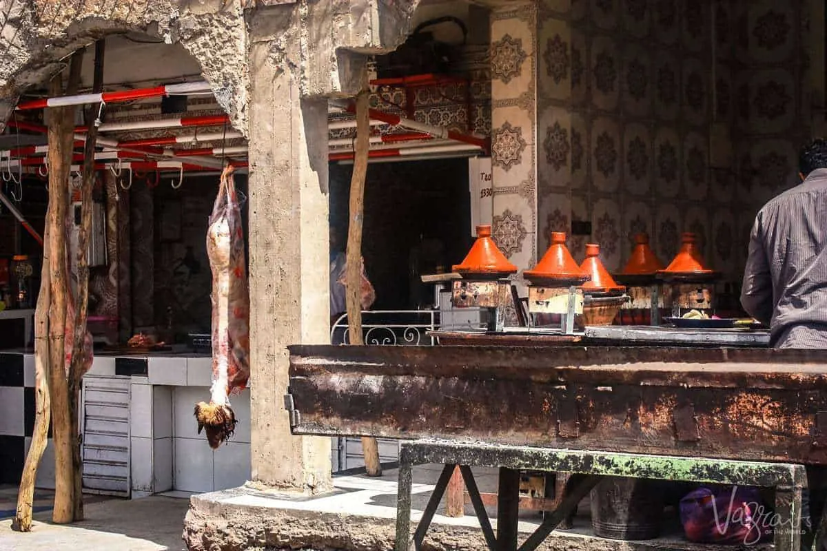 Restaurants in Zaida in the Midelt province Morocco with meat hanging in the front of the shop waiting to be butchered and a kitchen at the back with bbq off to the side. Great places to stop and eat on a moroccan road trip.