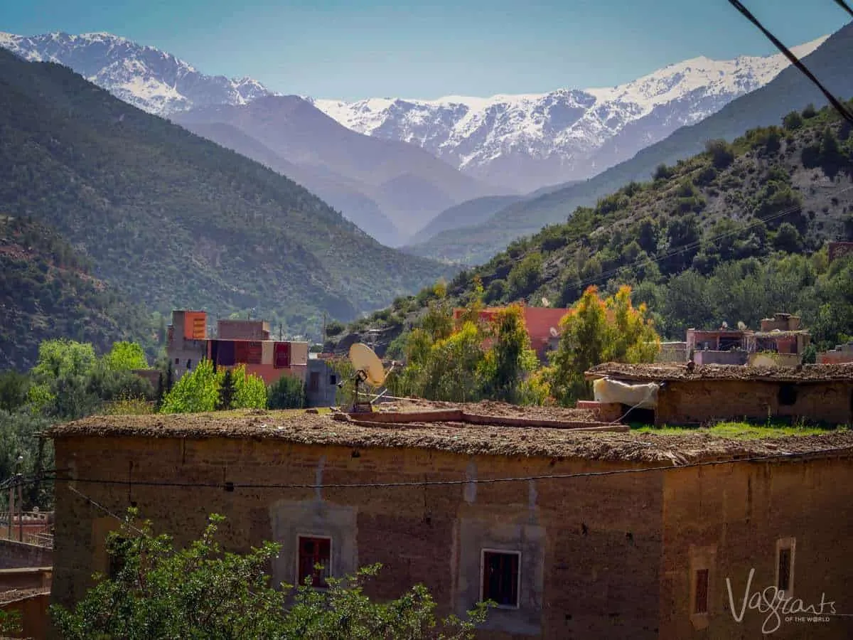 Marrakech to Fez Middle Atlas Mountains showing a roof top with snow covered mountains in the background. You get great views like this on a moroccan road trip