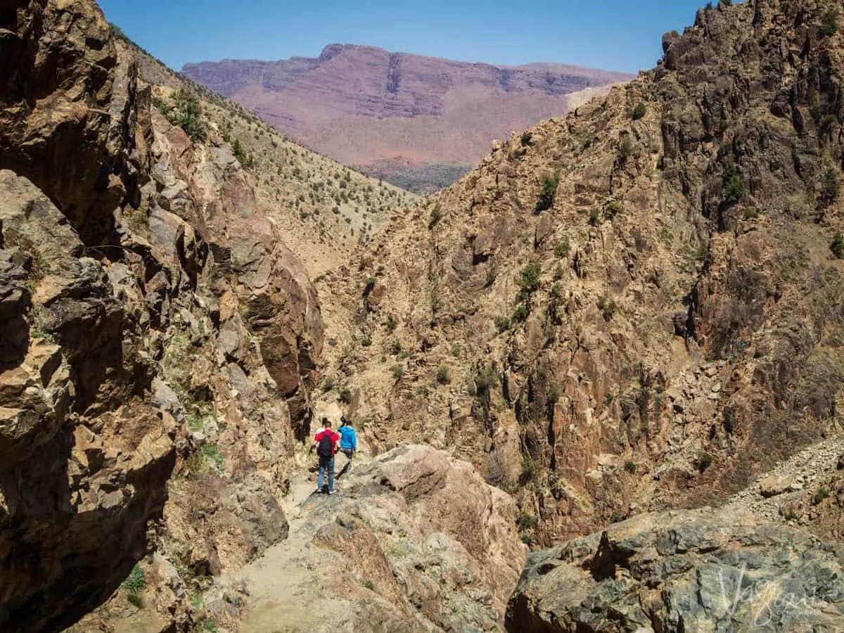The Middle Atlas Mountains - people walking along a rocky path in the gorge.