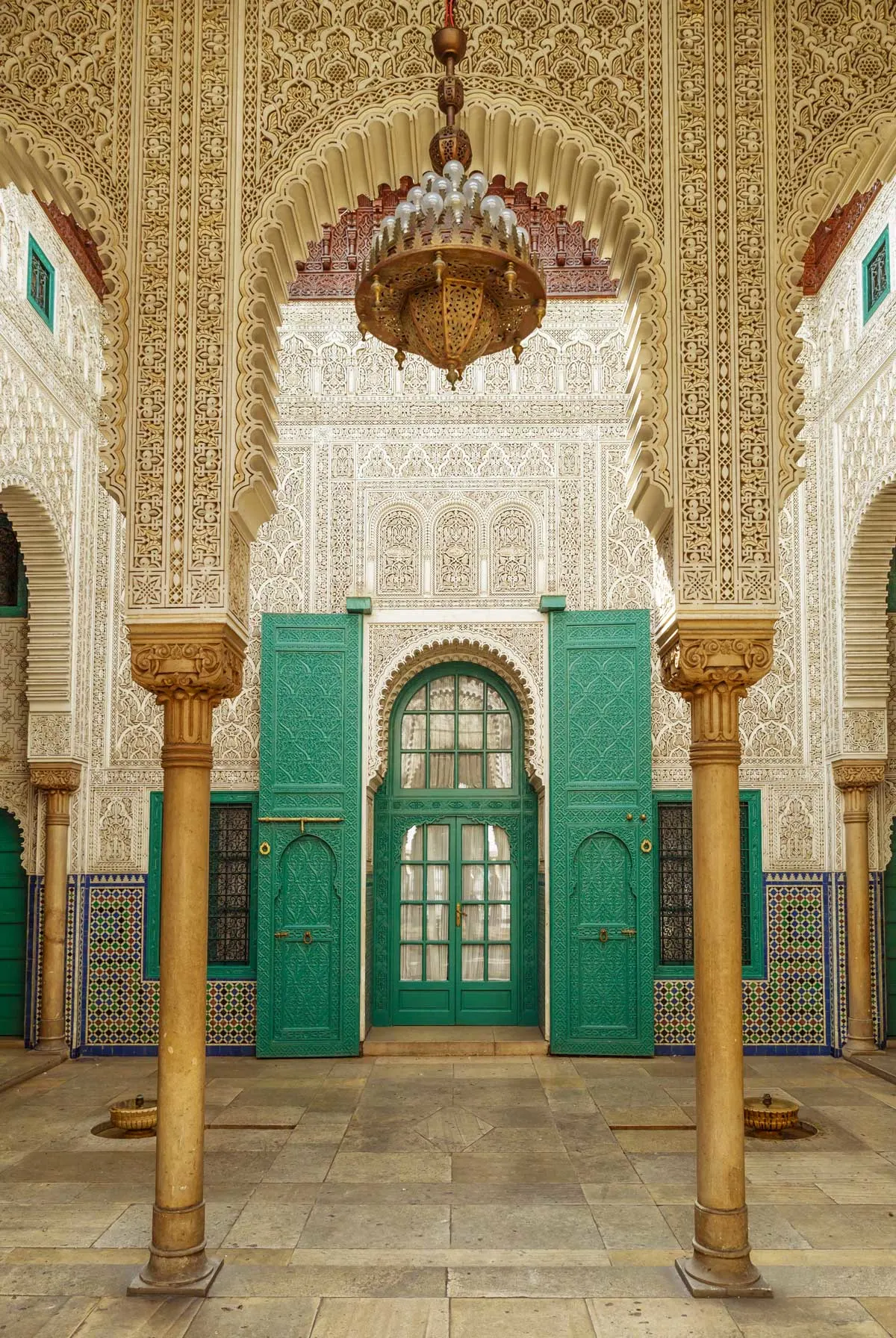 Ornate Moorish interior of the Pasha Palace with arched doorways and carved ceilings.