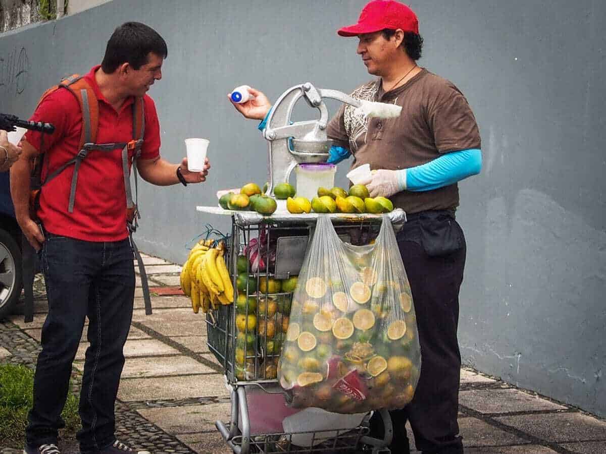 A man buying fresh lemonade from a street vendor in San Jose. 