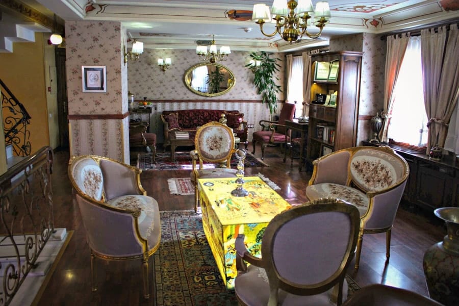 antique chairs around a lit coloured glass table in Dersaadet Hotel Istanbul Turkey. old city istanbul is the place to stay in istanbul as it will give you easy access to the top 10 things to see and do in istanbul