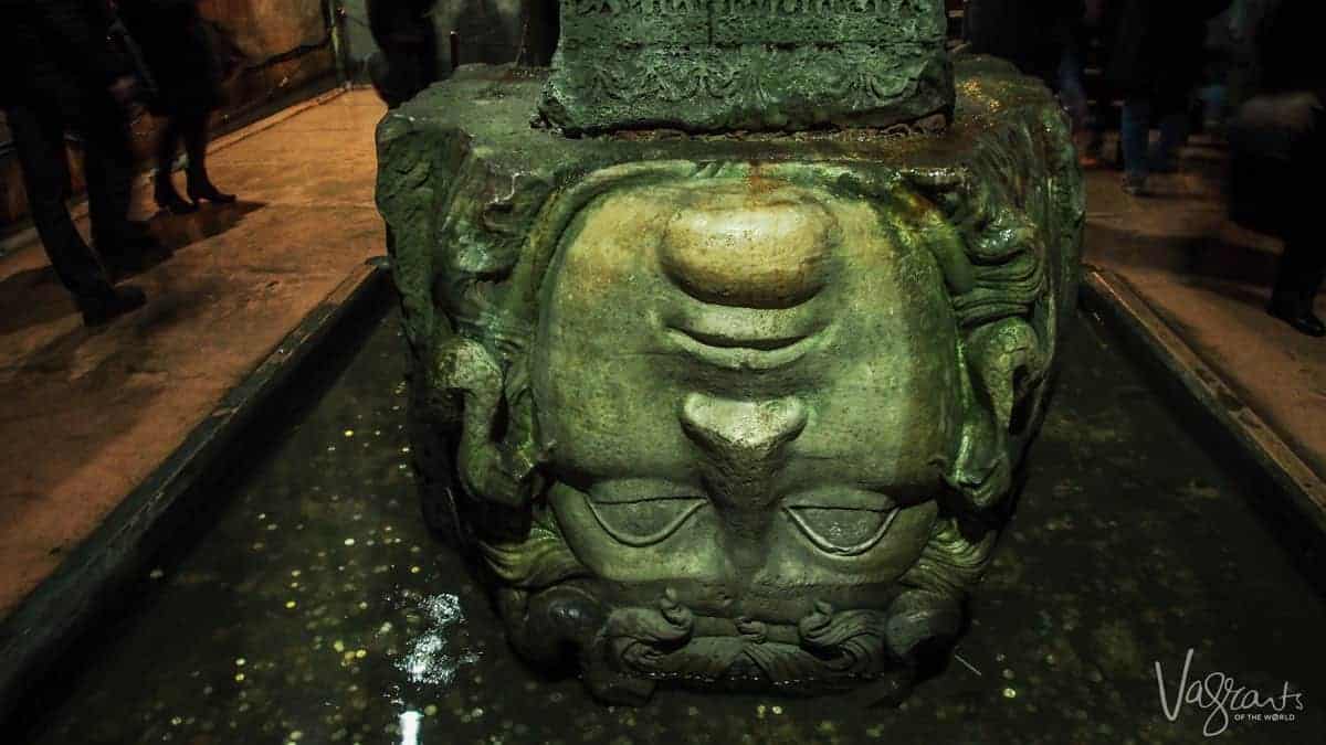 Medusa Head in a pool of water where coins have been thrown in the Basilica Cistern in Istanbul.