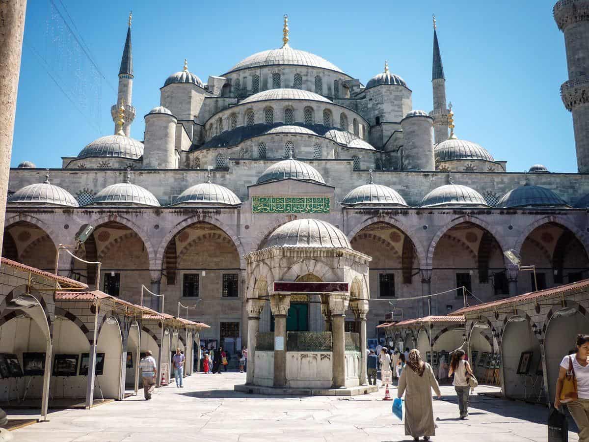 Street stalls on both sides of the walkway with people walking to the Blue Mosque.