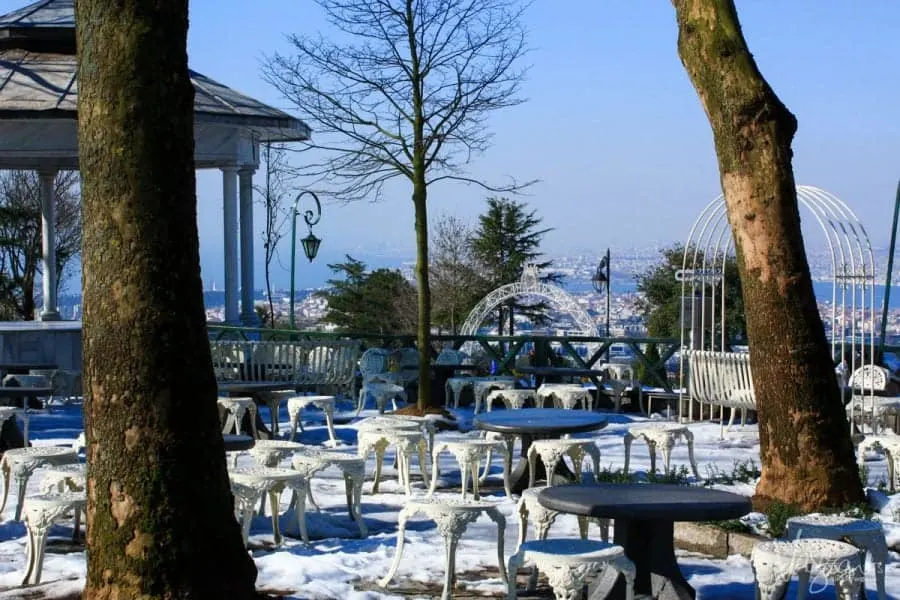 Outside dining tables and chairs sitting in the snow at Camlica Hill. 