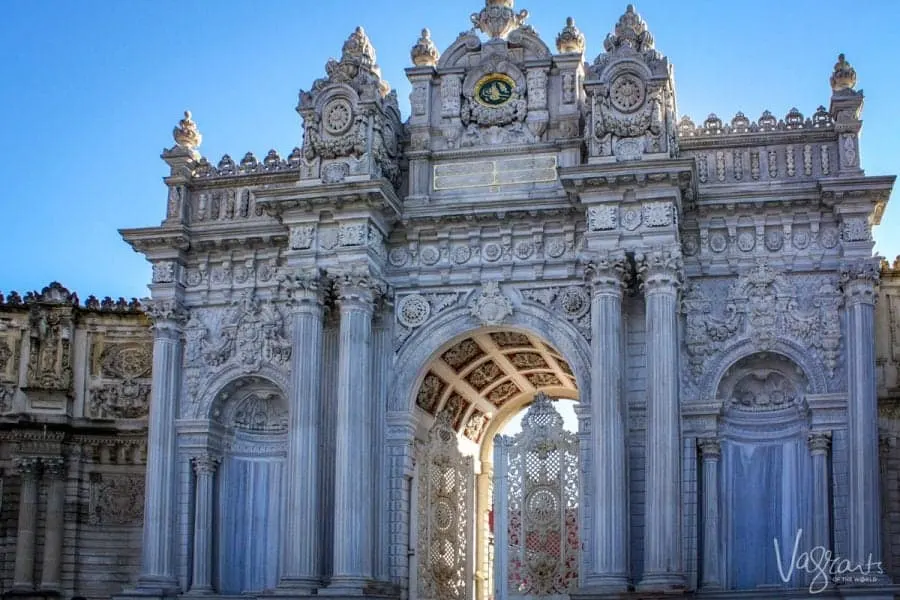 White and blue facade with columns and arched entry of Dolmabahçe Palace Istanbul.