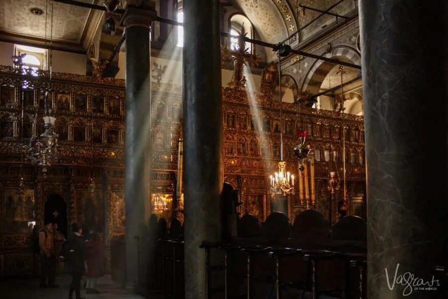 Sun rays coming through the window into the ornate interior of a Greek Orthodox church. 
