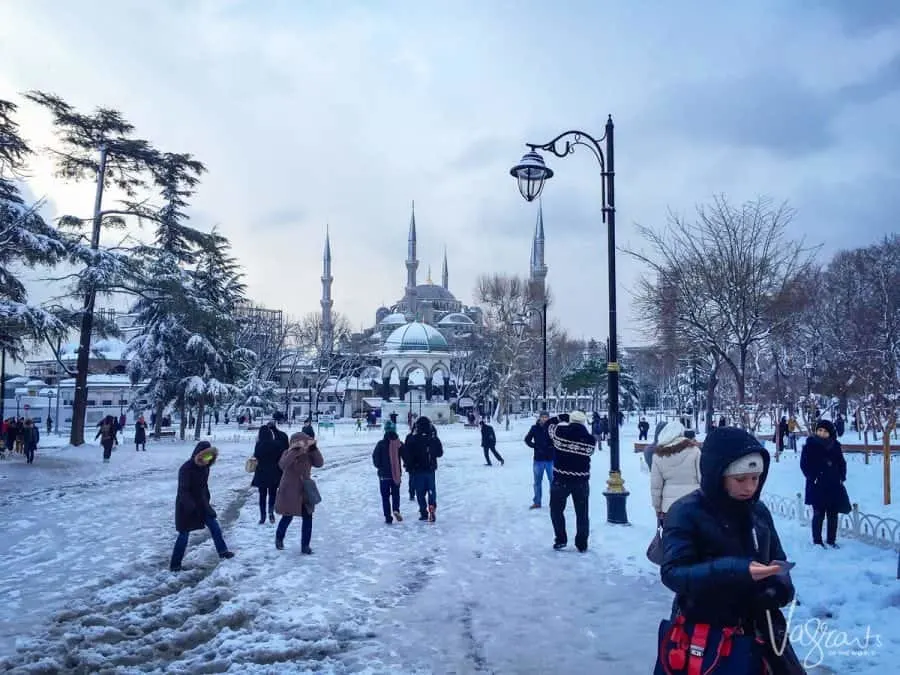 People carefully walking across the snow covered Sultanahmet Square, Istanbul.