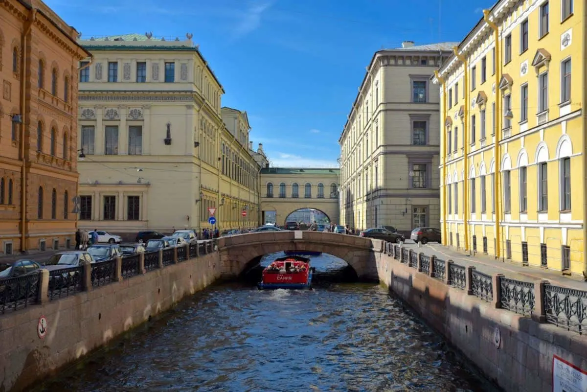boat going under a small bridge in canal area of St Petersburg. How much does it cost to get a Russian Visa, well that depends on where you get your russian visa but generally they are not cheap.