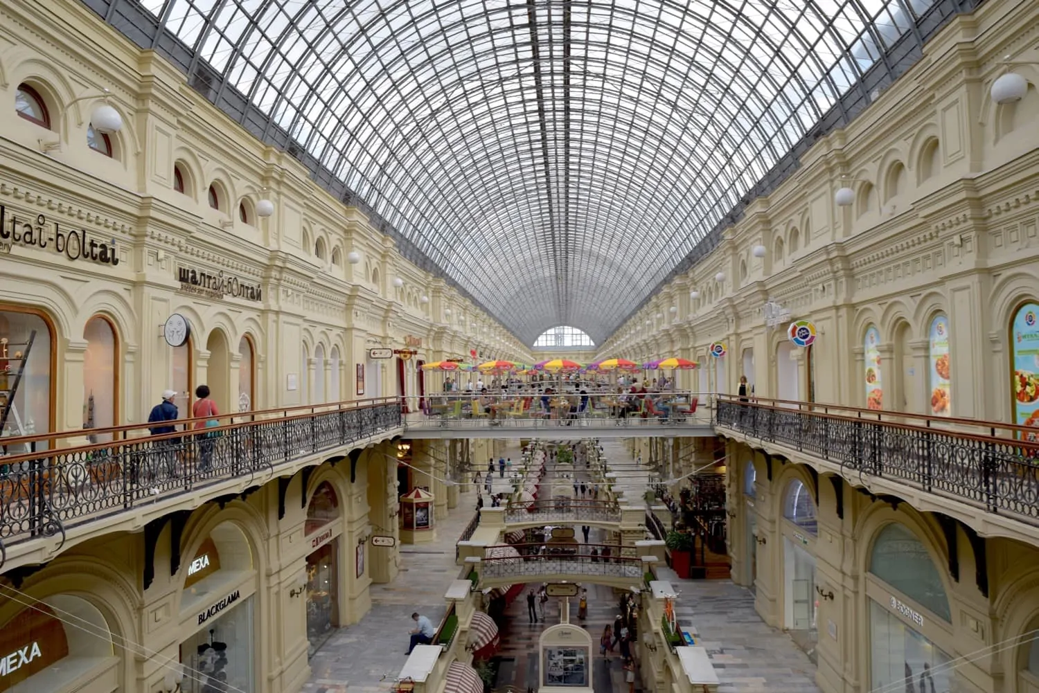 Inside GUM Department Store Russia with 2 levels of shopping in this ornate bulding. The glass domed roof tops the GUM department store one of the most famous places in russia