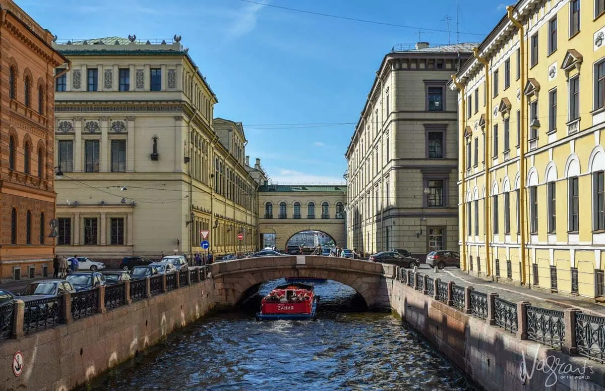 A Canal boat going under a bridge in the canals of St Petersburg.