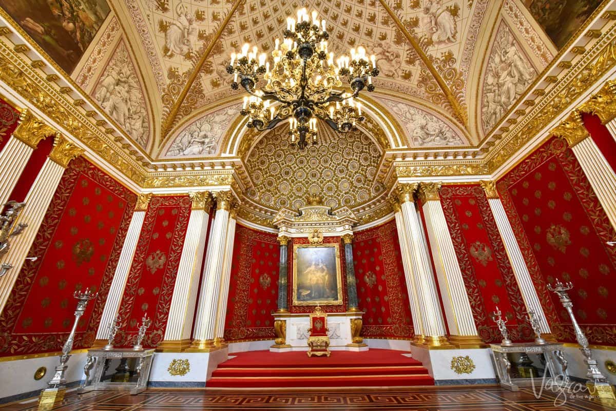 red walls, gold ceiling and chandelier before a portrait. one of the very best things to do in st petersburg is to visit the hermitage museum, but you need plenty of time so that you will find and enjoy some of the hidden gems in the hermitage museum