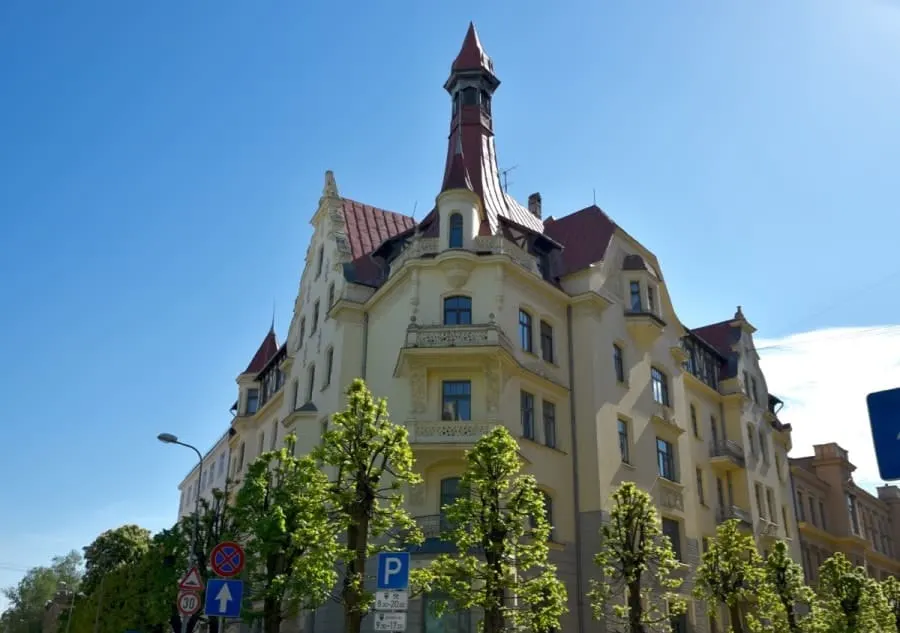 Steepled yellow corner building in the Art Noveau District Riga Latvia. There are plenty of free things to do in Riga. Latvia and checking out these buildings is a highlight of any Riga itinerary.