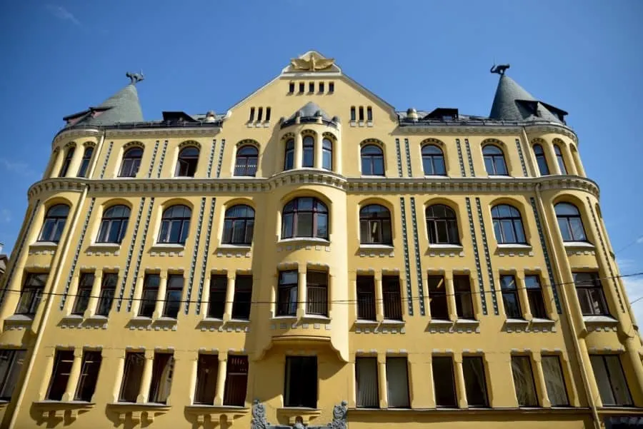 Yellow gothic building with 2 black cats on the spires. Known as the Cat House Riga, Latvia. Another great free thing to see in Riga