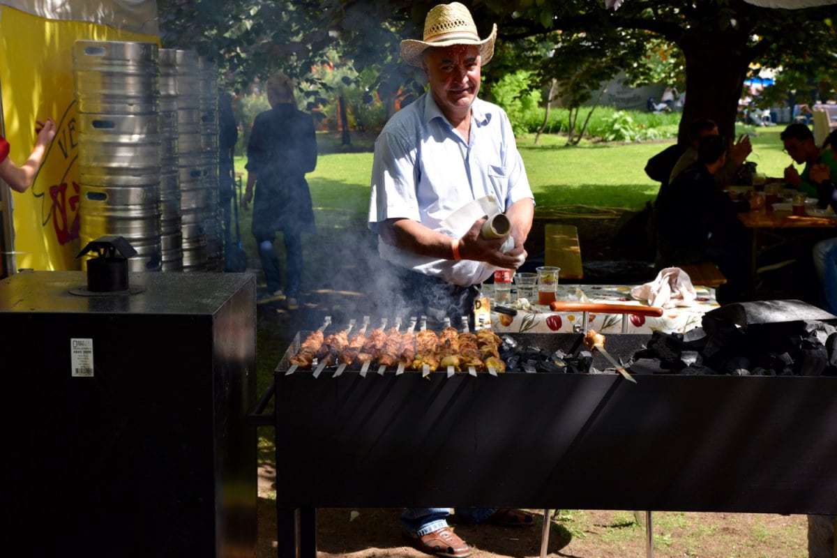 man cooking skewers of meat on bbq at the Latvian Beer Festival, Riga. Unusual things to do in Riga