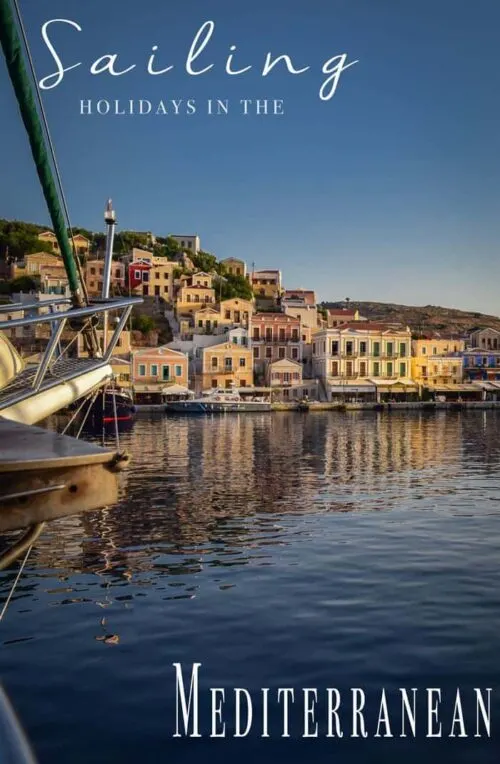 Looking across the bow of a yacht to the colourful houses on Symi Island Greece