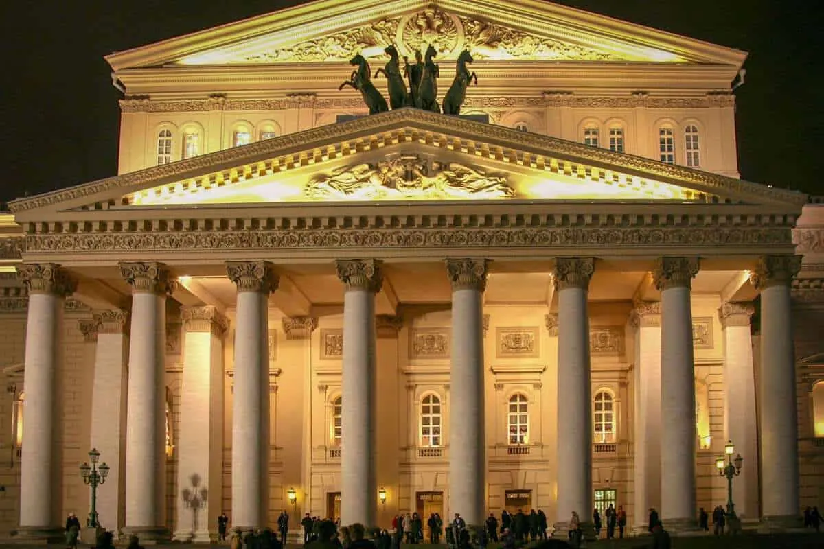 The Bolshoi Theatre Moscow Russia with the white flower garden in the foreground.What should a traveler visiting Moscow know about visiting the ballet. That it is a mandatory item on your travel schedule.