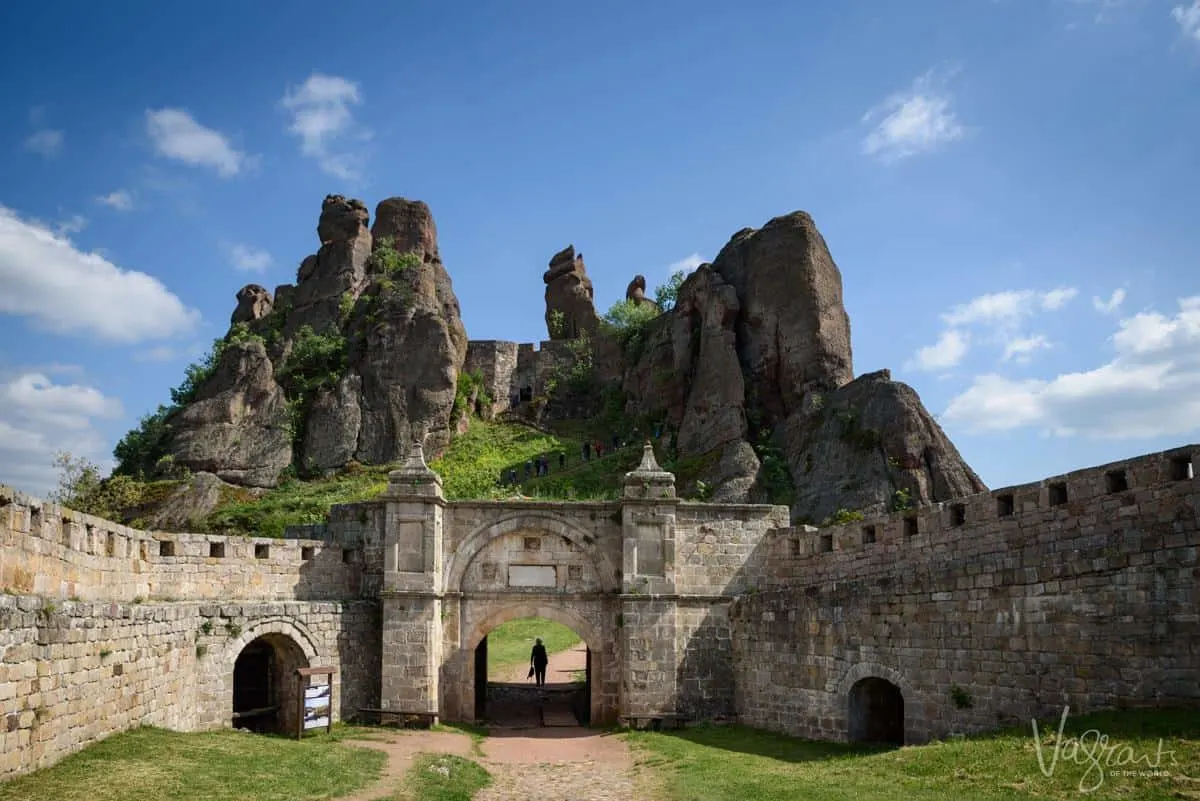 A person walking through the main gate of the Belogradchik Rocks and fortress in Bulgaria. 