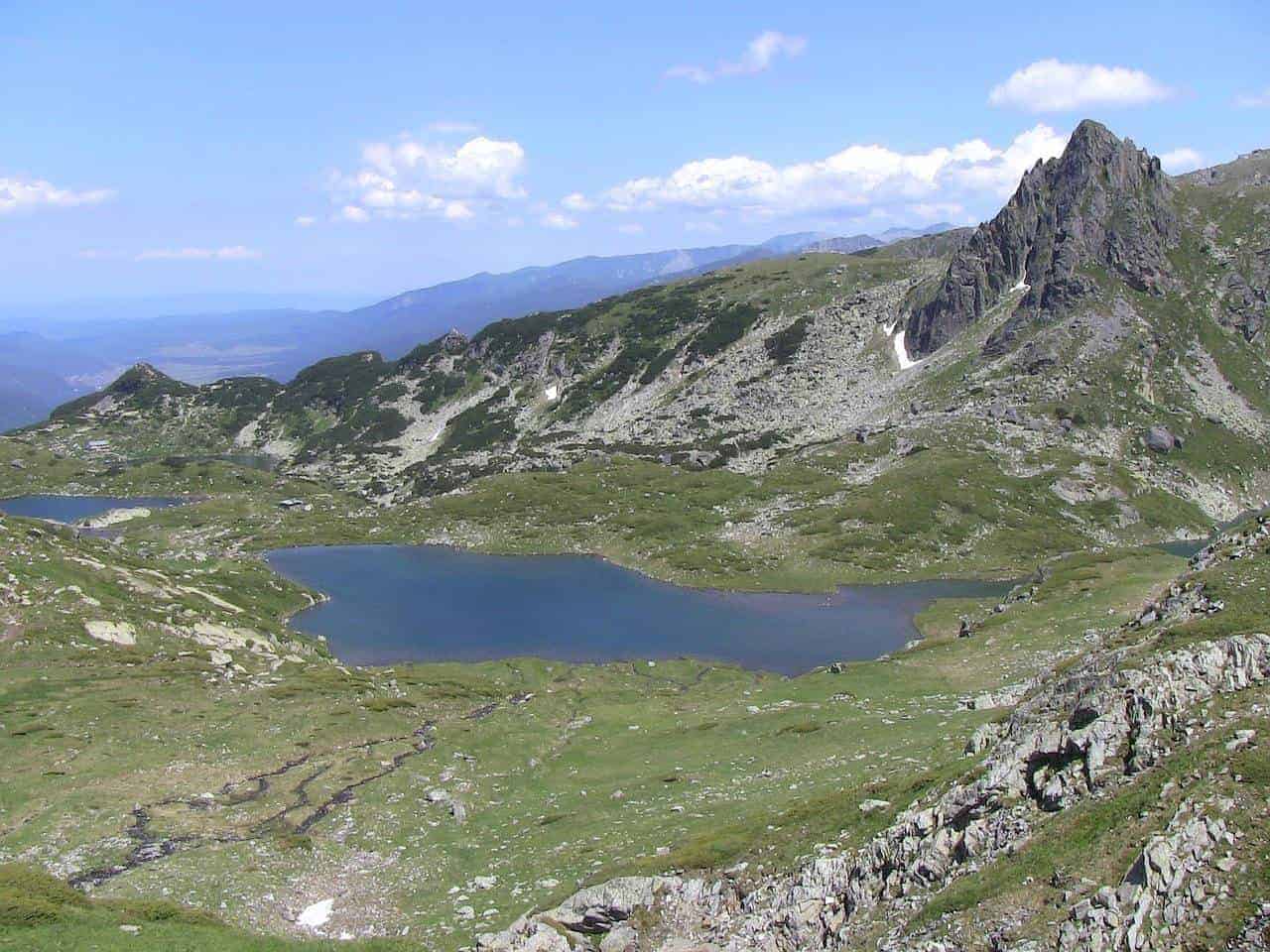 Mountain peaks surrounding a blue lake at Seven Rila Lakes Bulgaria. 