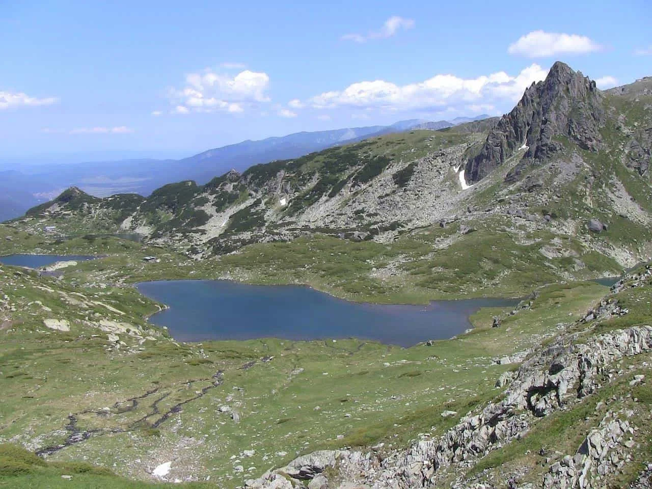 Mountain peaks surrounding a blue lake at Seven Rila Lakes Bulgaria. 