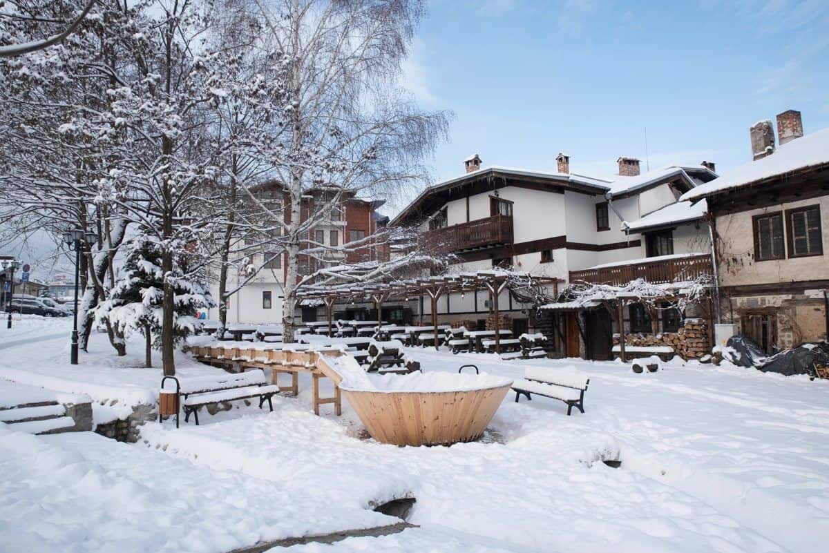 Snow piled around the stone and timber houses of Bansko old town