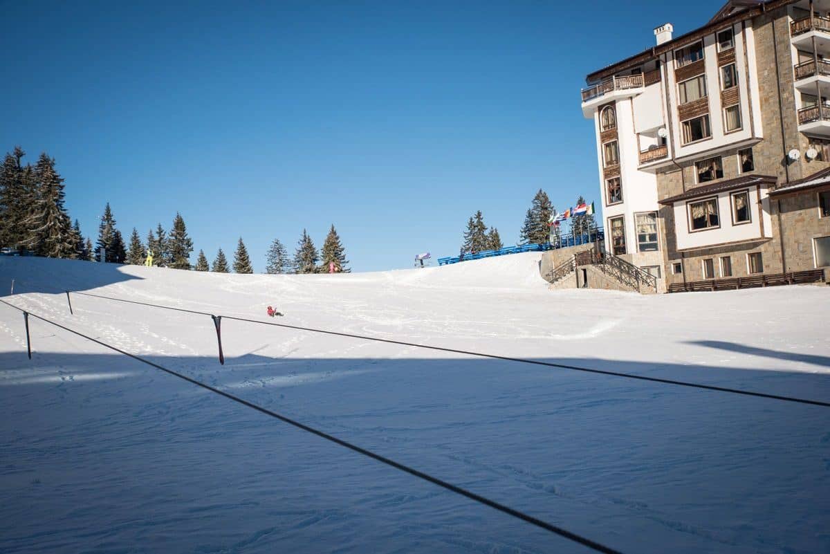 A ski-in ski-out hotel sitting directly on the piste at Pamporovo under blue sky