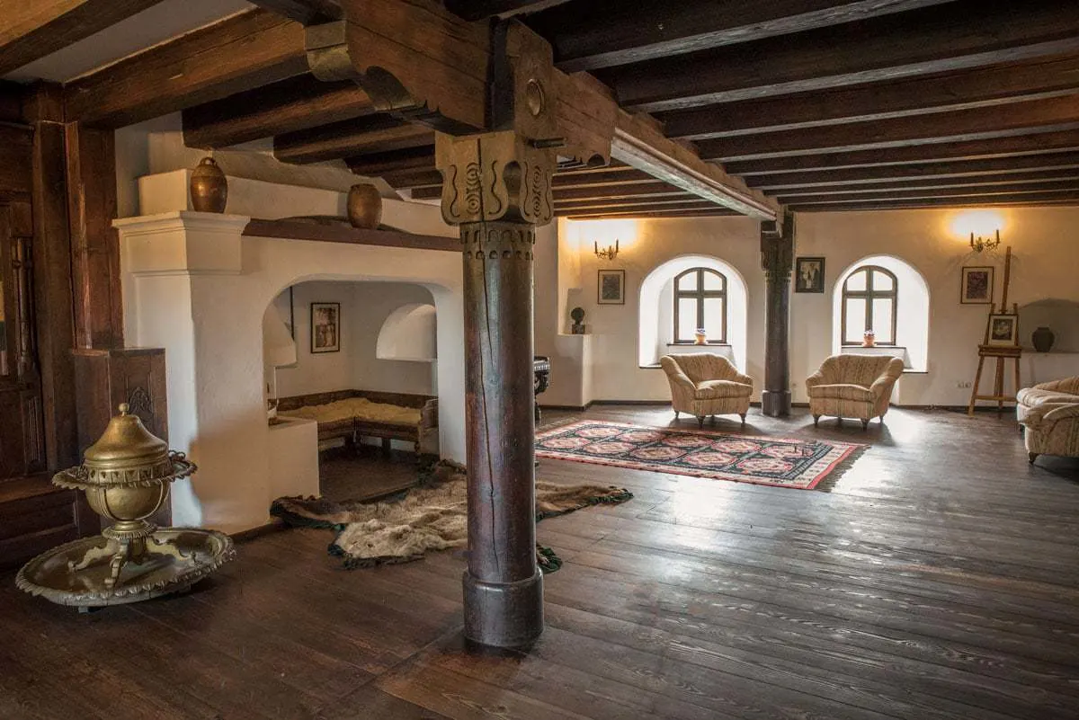 A lounge and fireplace inside the wooden rooms of Dracula's castle in Romania.