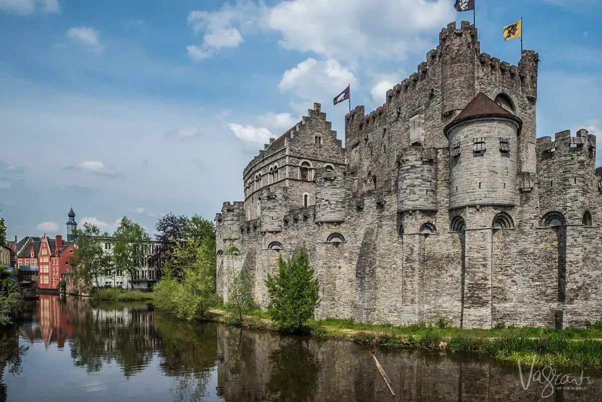 Castle of the Counts ghent Belgium with medieval turrets and walls surrounded by a canal. Which cities are the best to visit in Belgium, Ghent is our recommendation. 