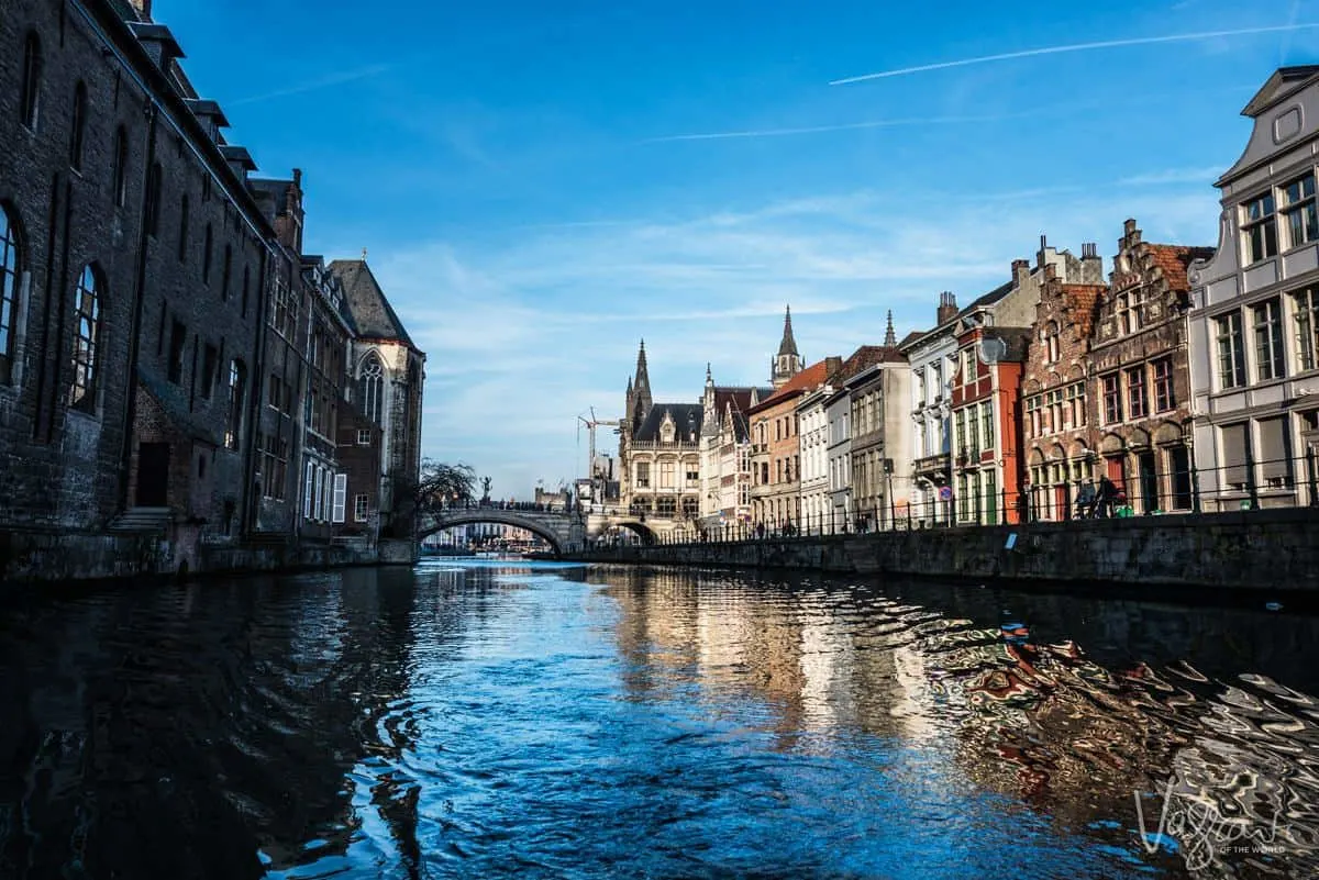 Ghent Boat Tour with a view of the canal and arched bridge with ornate buildings lining both sides of the canal. This is why visiting Ghent is one of the best things to do in Belgium 