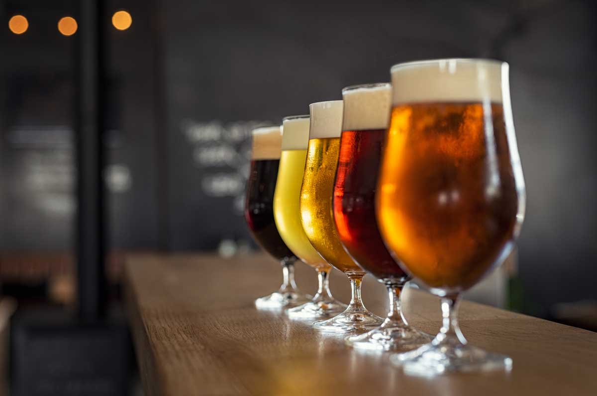 Glasses of craft beer of different colours in a line. 