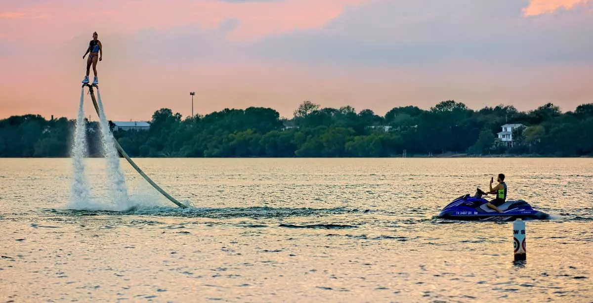 Girls riding a water rocket with a guy on a jetski on Lake Arlington. 