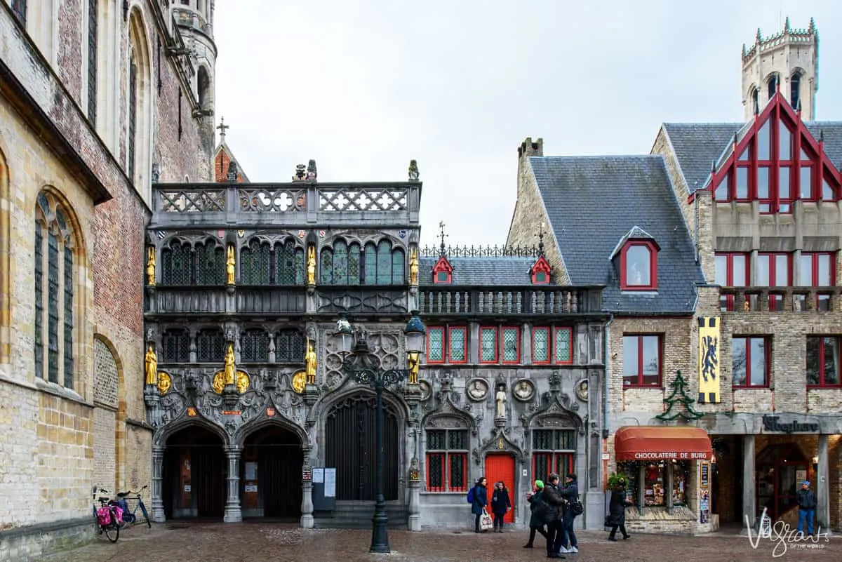 Tourists standing in front of the ornate Church of the Holy Blood in Bruges. 