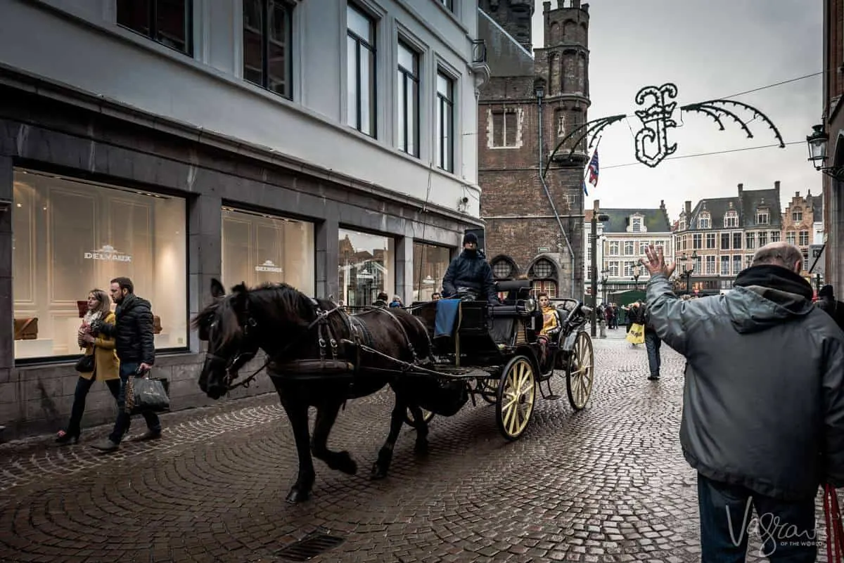 Horse and carriage moving through the medieval centre of Bruges. 