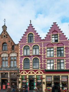 Colourful brick buidlings with pointed roofs in the market square in Bruges.
