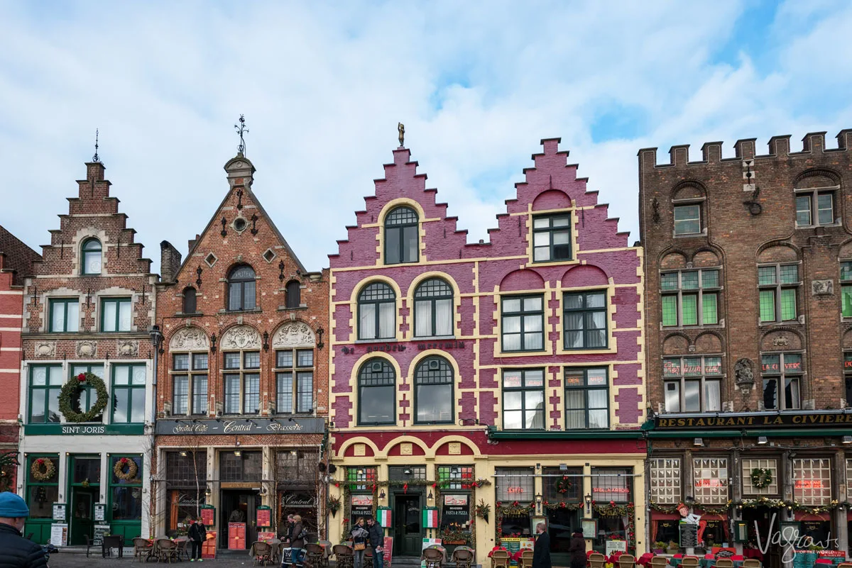 Colourful brick buidlings with pointed roofs in the market square in Bruges.