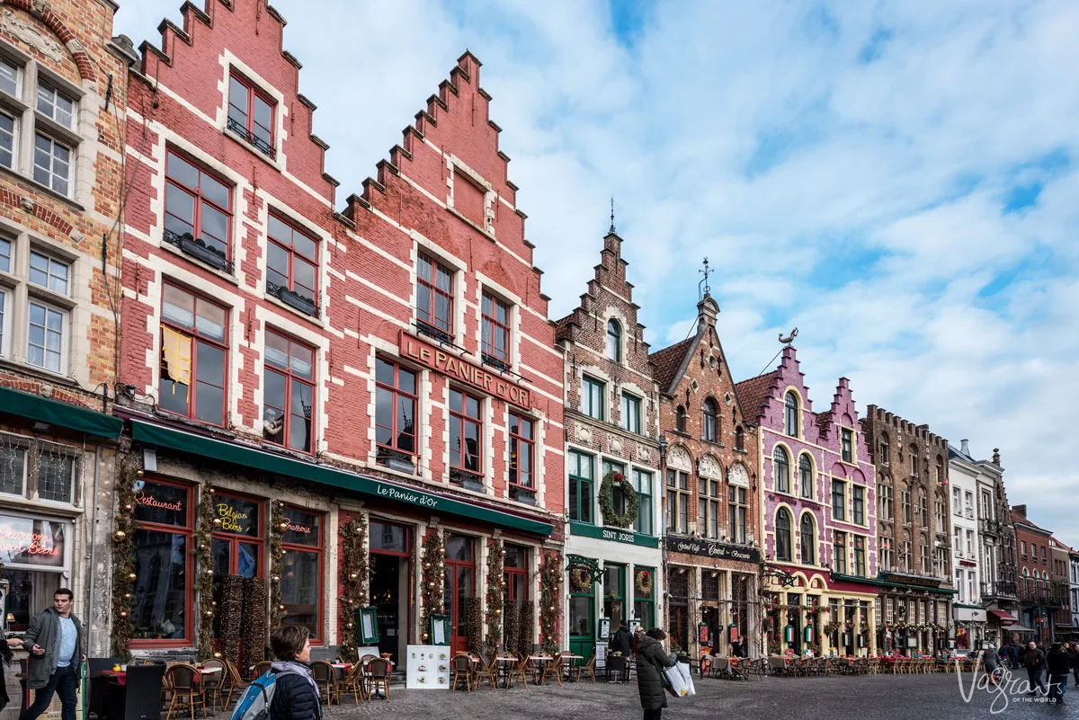 Rows of colourful buidlings with pointed roofs decorated for Christmas in Bruges Belgium.