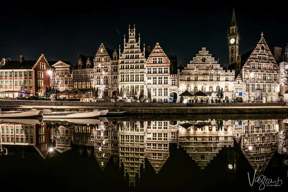 Best things to do in Ghent - Night walking tour highlighting all of the buildings and their reflections in the canals. Stunning clock and tower in the background. Which cities are the best to visit in Belgium - Ghent of course 