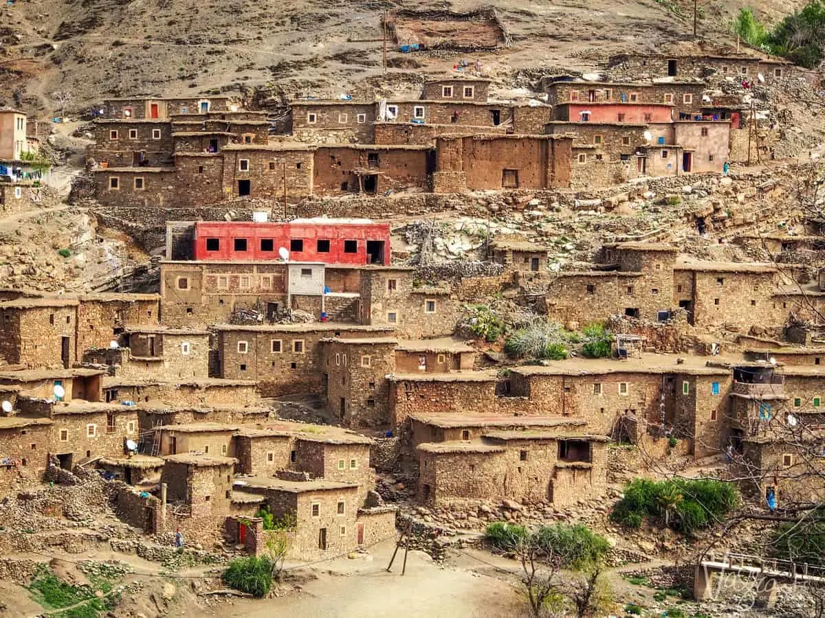 Heading to the sahara desert on a moroccan road trip, Marrakech to Fez Atlas Mountains with traditional stone houses built into the hillside.