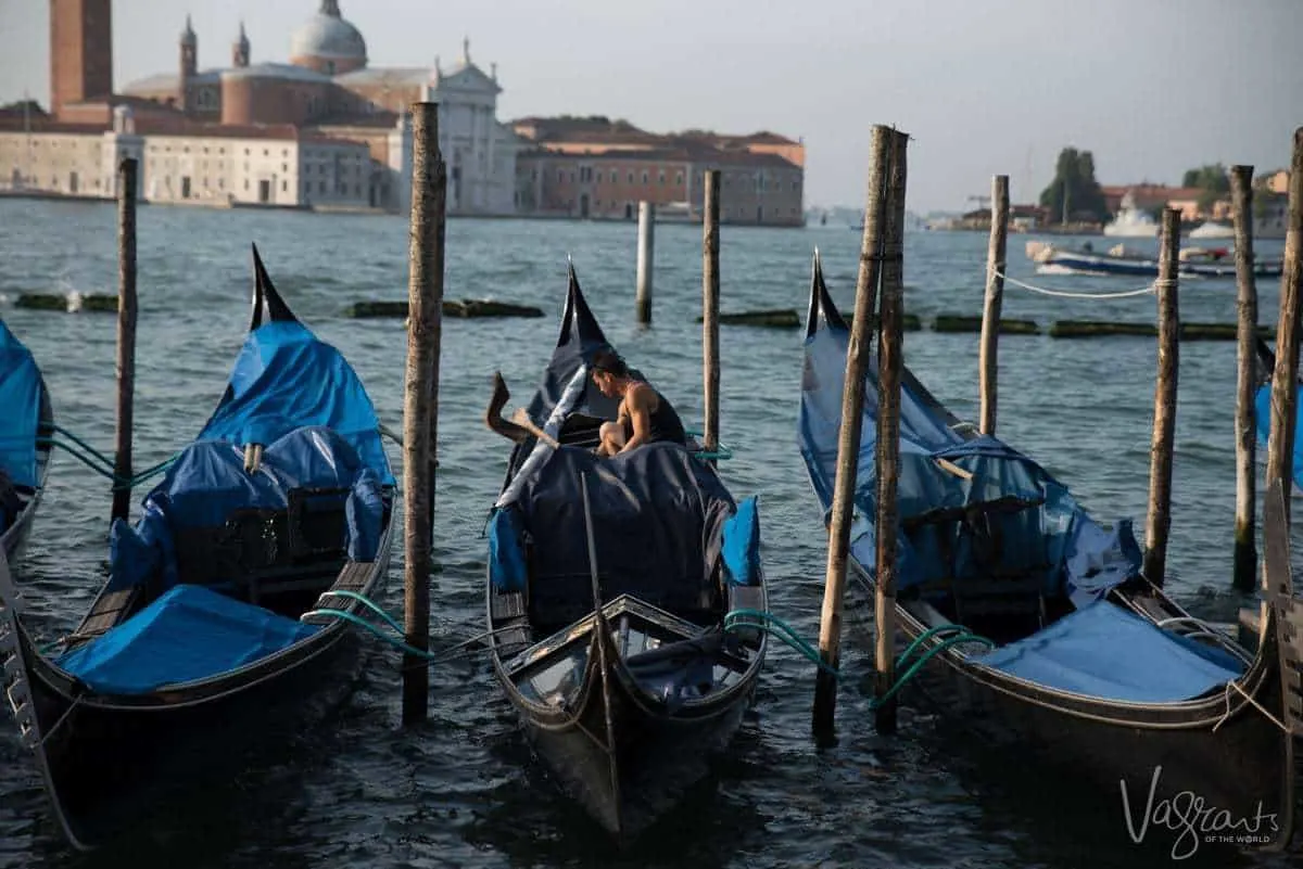A gondolier preparing the gondolas early in the morning in Venice.