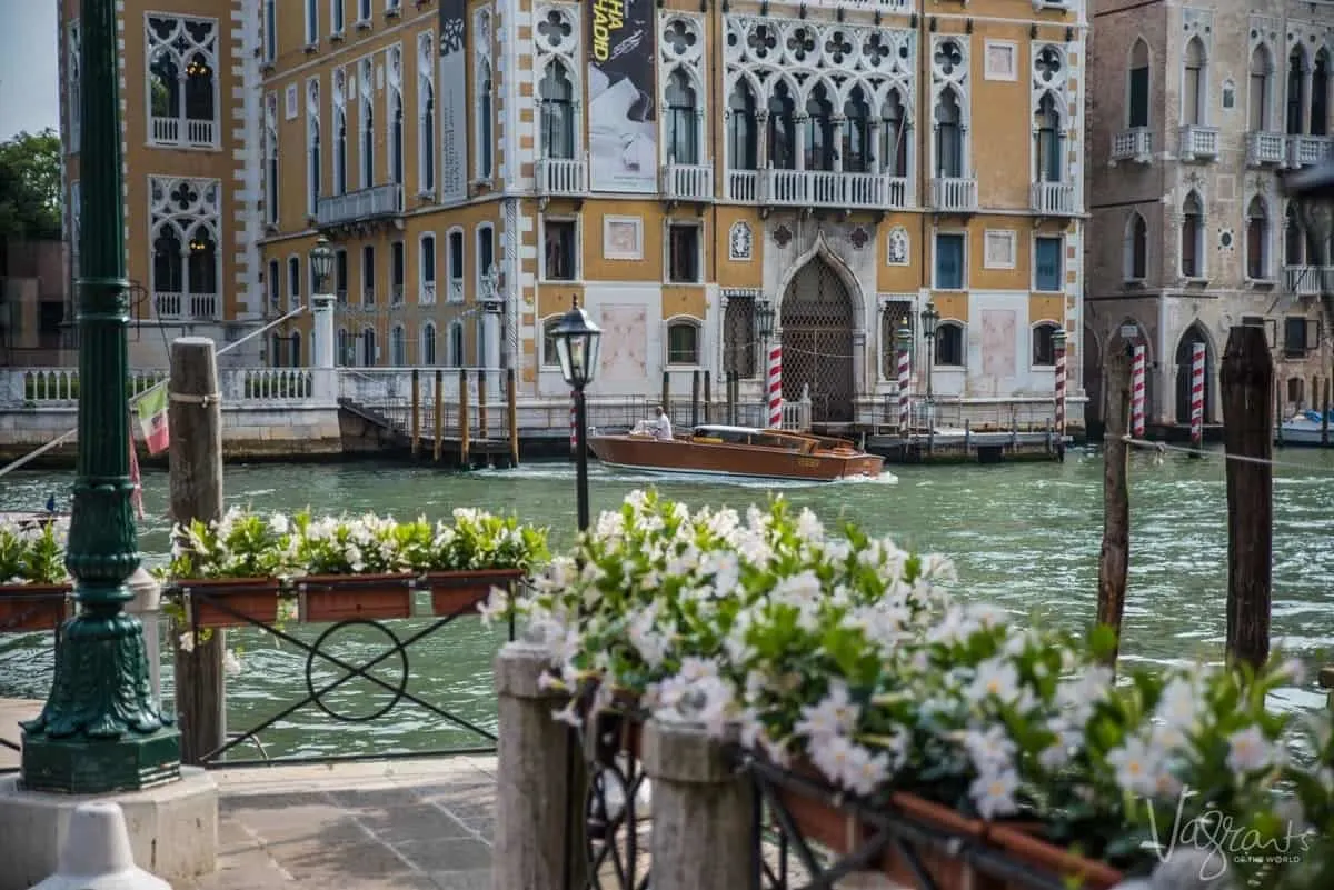 A boat travelling down the Grand Canal in Venice, lined with historic palazzos.