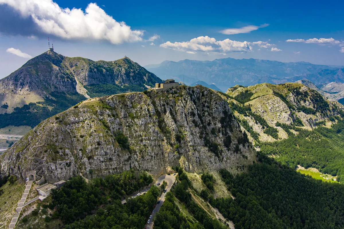 Mountain landscape in Lovcen National Park with the Lovcen Mausoleum perched on top of a mountain peak. 