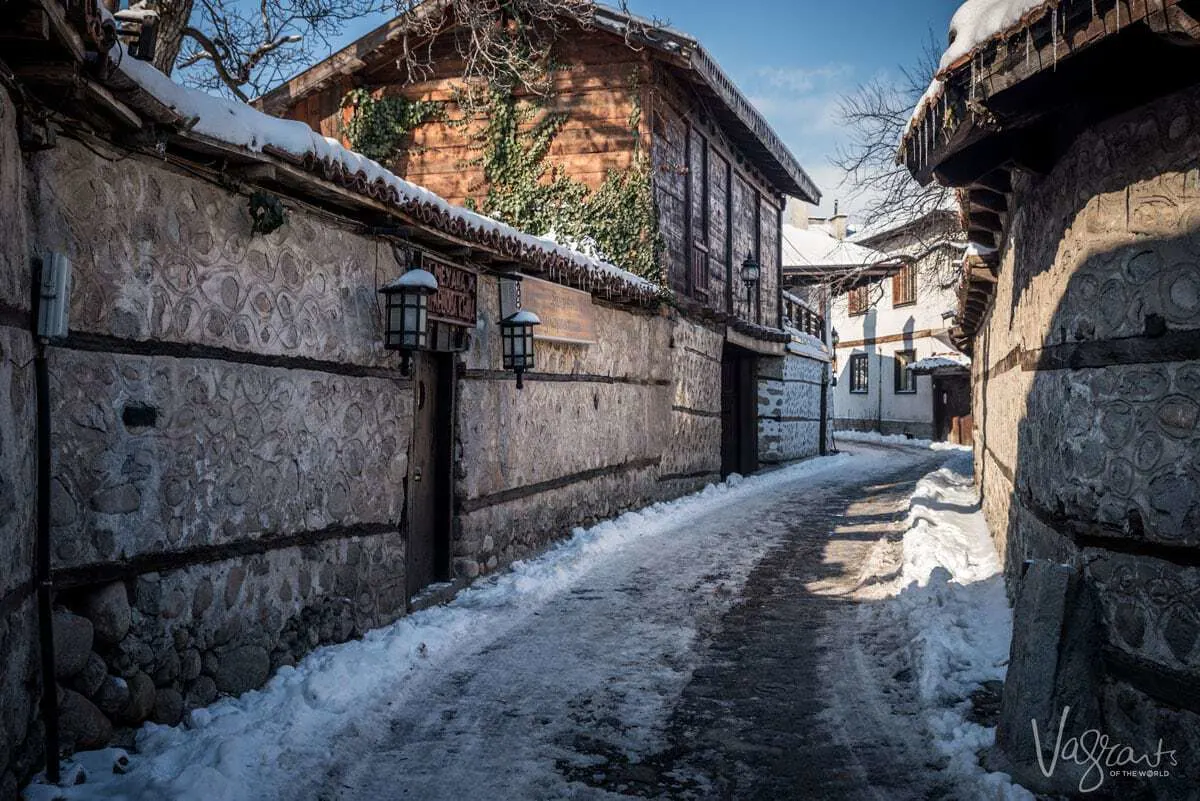 Typical stone houses and snowy cobble streets Old town Bansko Bulgaria