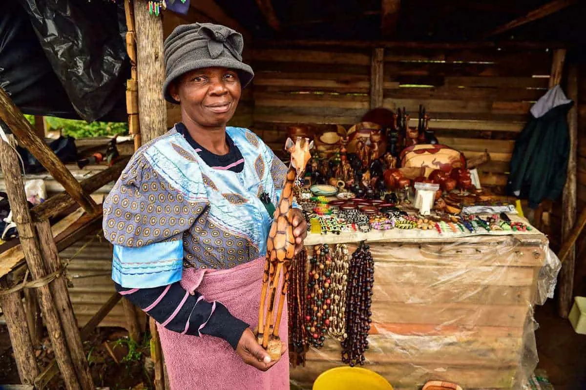Souvenir seller holding a wooden giraffe in Graskop South Africa. It is always nice to support the local traders during your panorama route itinerary.